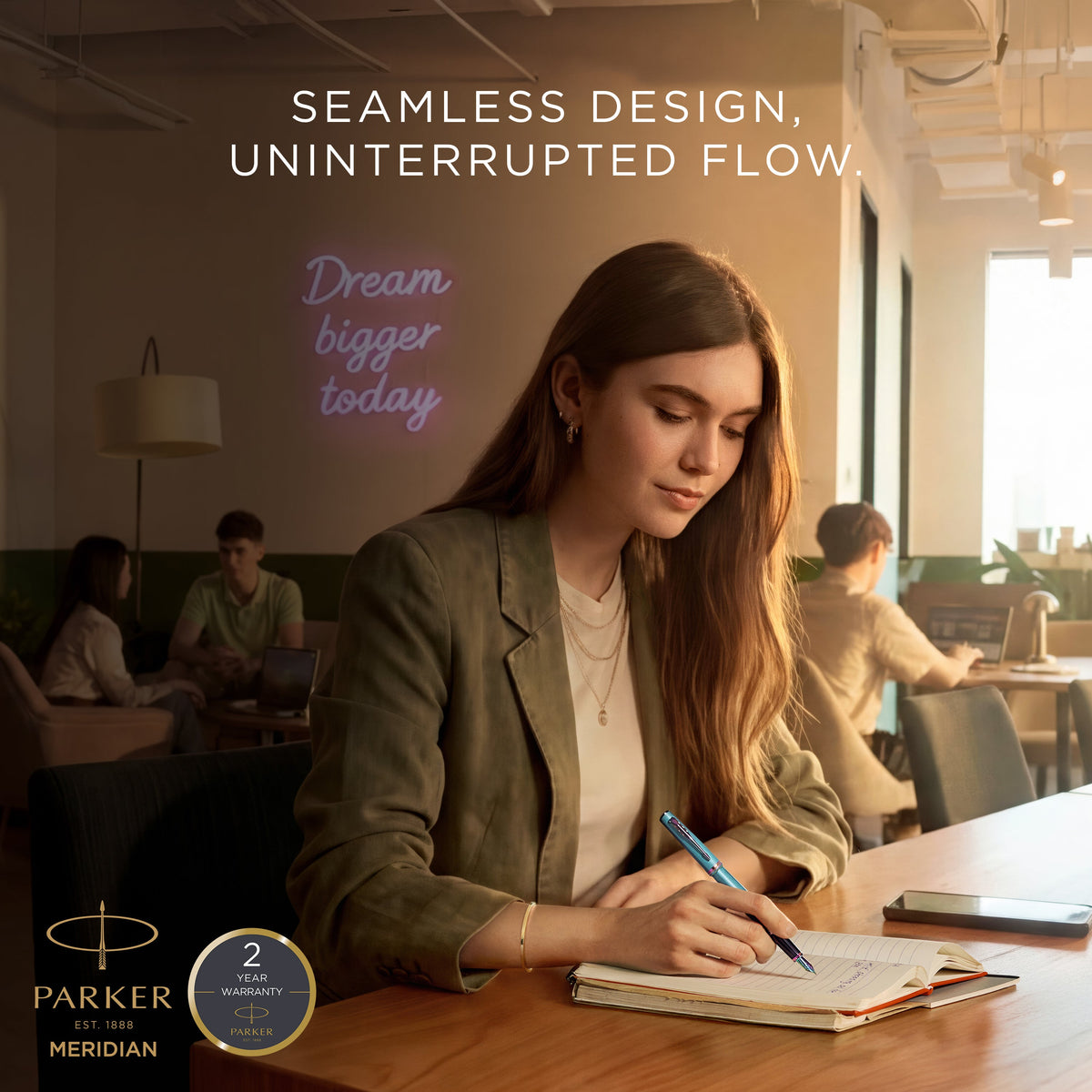 Woman journaling at a cafe table with a Parker Meridian ballpoint, captioned seamless design, uninterrupted flow