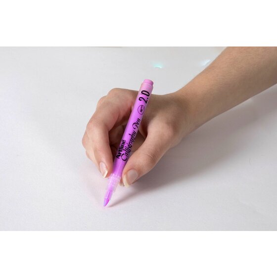 Hand writing with a pastel purple Artline Calligraphy Pen 2.0